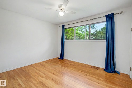 Wood-finish flooring, white walls, and a multi-pane window - 10830 138 Street Nw, Edmonton, AB 