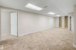 Spacious room featuring neutral wall tones, durable tile flooring, and a drop ceiling with integrated lighting - 