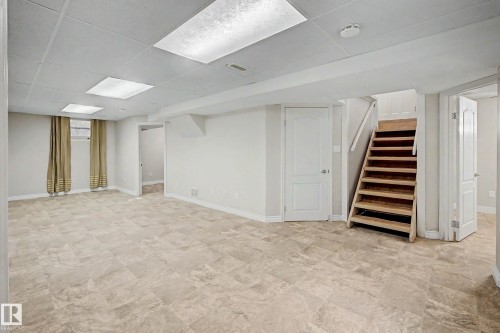 Spacious room featuring neutral tone flooring, recessed lighting, and a drop ceiling - 10830 138 Street Nw, Edmonton, AB 