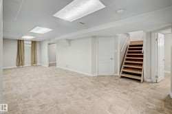 Spacious room featuring neutral tone flooring, recessed lighting, and a drop ceiling - 