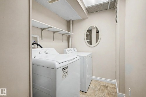 Dedicated laundry area featuring a skylight, overhead shelving, and a neutral color palette - 10830 138 Street Nw, Edmonton, AB 