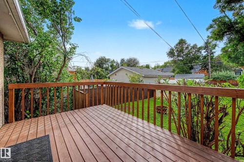 Expansive wood deck with a full railing overlooking a green lawn - 10830 138 Street Nw, Edmonton, AB 