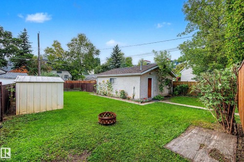 Expansive lawn area, detached auxiliary building with stucco finish, additional storage shed, and perimeter fencing - 10830 138 Street Nw, Edmonton, AB 