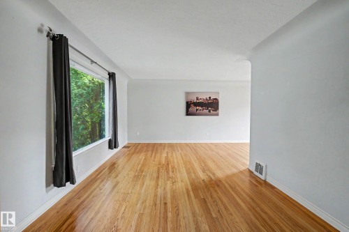 Hardwood flooring throughout, bright window, and neutral wall finishes - 10830 138 Street Nw, Edmonton, AB 