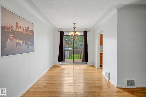 Hardwood flooring, white walls, and a ceiling-mounted chandelier - 10830 138 Street Nw, Edmonton, AB 