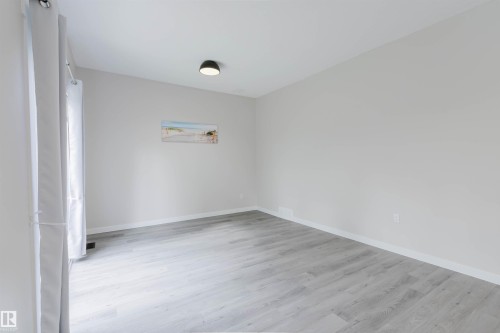 Light gray wood-finish flooring, white walls, and a modern ceiling light fixture - 10423 35 Avenue Nw, Edmonton, AB 