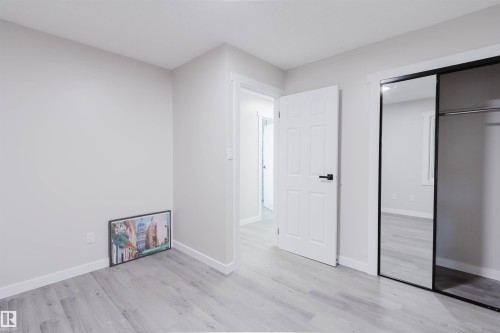 Light gray walls complement the wood-finish flooring - 10423 35 Avenue Nw, Edmonton, AB 