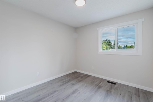 Light-toned walls, wood-finish flooring, white trim, and a ceiling-mounted light fixture - 10423 35 Avenue Nw, Edmonton, AB 