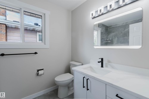 Vanity with integrated sink, matte black faucet, and white countertop - 10423 35 Avenue Nw, Edmonton, AB 