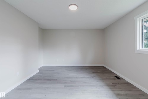 Light gray wall paint, white trim, wood-finish flooring, and a single window - 10423 35 Avenue Nw, Edmonton, AB 