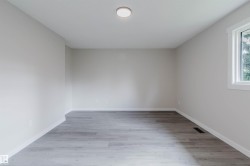 Light gray wall paint, white trim, wood-finish flooring, and a single window - 