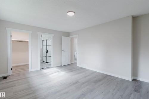 Light wood-finish flooring, white trim, and light gray wall paint - 10423 35 Avenue Nw, Edmonton, AB 
