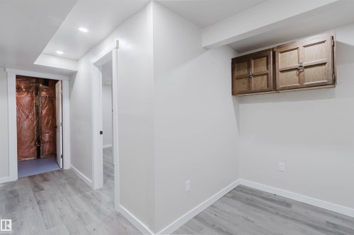 Recessed lighting, wood-finish flooring, white walls, and built-in wood cabinetry - 10423 35 Avenue Nw, Edmonton, AB 
