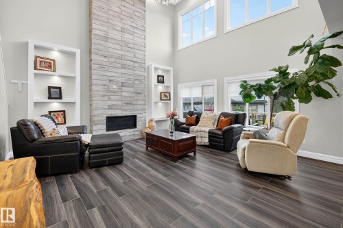 High ceilings with upper windows, integrated wall shelving, a floor-to-ceiling fireplace - 94 Westlin Drive, Leduc, AB 