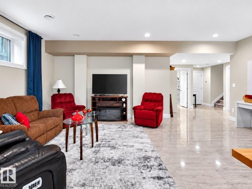Recessed lighting, light-toned walls, and a built-in media console with an electric fireplace - 94 Westlin Drive, Leduc, AB 