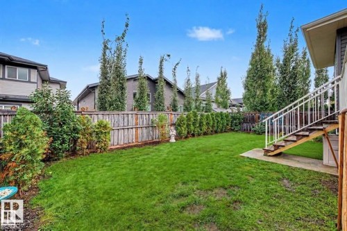 Expansive green lawn with established perimeter landscaping and mature trees - 94 Westlin Drive, Leduc, AB 