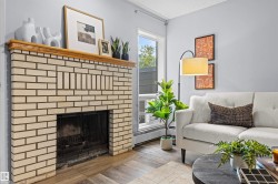 Fireplace with light brick surround and wood mantle - 