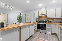 Kitchen featuring wood-finish countertops, white cabinetry with wood trim, stainless steel appliances, wood-finish backsplash, and recessed lighting - 