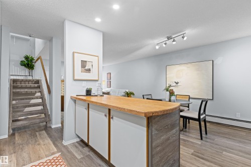 Built-in cabinetry with wood-finish countertop, recessed lighting, track lighting, and wood-finish flooring - #7 10032 113 St Nw, Edmonton, AB 