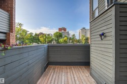 Private outdoor space with wood-finish decking and perimeter fencing - 