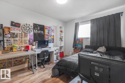 Wood-finish flooring, white walls, built-in shelving, and a prominent window with dark curtains - 8808 43 Avenue Nw, Edmonton, AB 