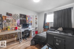 Wood-finish flooring, white walls, built-in shelving, and a prominent window with dark curtains - 