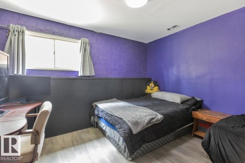 Light wood-finish flooring, purple wall finish, and a ceiling-mounted light fixture - 8808 43 Avenue Nw, Edmonton, AB 