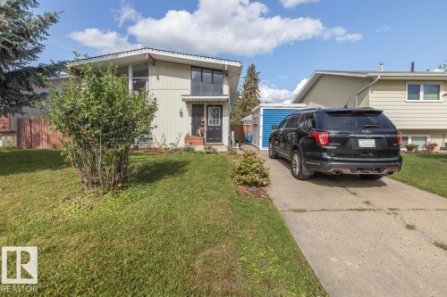 Split-level residence featuring a concrete driveway, established front landscaping, an exterior storage shed, and a fenced side yard - 8808 43 Avenue Nw, Edmonton, AB 