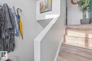 Wood-finish staircase with solid risers and a contemporary white handrail - 8808 43 Avenue Nw, Edmonton, AB 