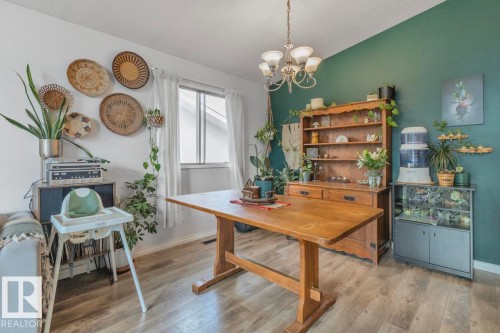 Wood-finish flooring throughout, natural light from a double-pane window, and a built-in wood hutch with shelving - 8808 43 Avenue Nw, Edmonton, AB 