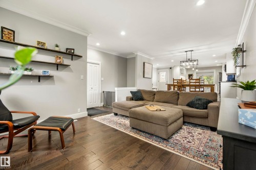Open-concept living area with dark wood-finish flooring, recessed lighting, crown molding, and built-in shelving - 11 Brunswick Crescent, St. Albert, AB 