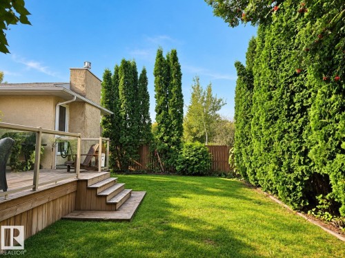 Wood deck with glass panel railing and integrated steps to the lawn - 11 Brunswick Crescent, St. Albert, AB 