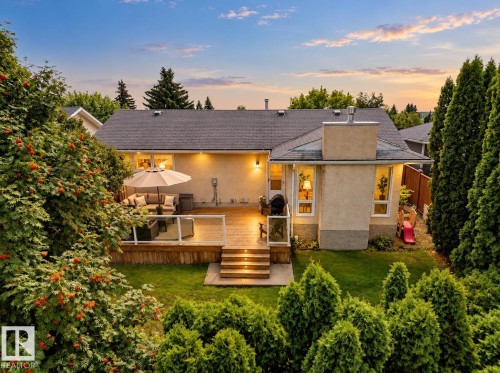 Expansive backyard with a multi-level wood deck, glass panel railing, and integrated deck lighting - 11 Brunswick Crescent, St. Albert, AB 