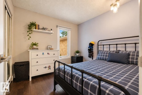 Wood-finish flooring with a single window, a built-in closet with sliding doors, an overhead light fixture, and neutral wall tones - 11 Brunswick Crescent, St. Albert, AB 