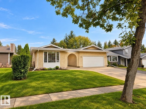 Stucco exterior with an attached two-car garage, mature front yard landscaping, and a concrete driveway - 11 Brunswick Crescent, St. Albert, AB 
