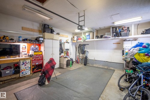 Concrete flooring with fluorescent lighting, built-in shelving, and white storage cabinetry - 11 Brunswick Crescent, St. Albert, AB 