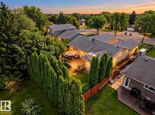 Expansive backyard with wood deck, privacy hedge, and mature landscaping - 11 Brunswick Crescent, St. Albert, AB 