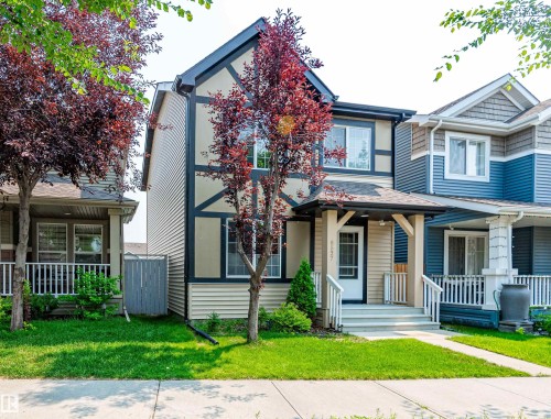 Two-story home featuring a combination of cream siding and stucco with dark trim accents - 8527 Ellis Link Nw, Edmonton, AB - Outdoor With Deck Patio Veranda With Facade
