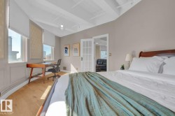 Wood-finish flooring, exposed beam ceiling, multiple windows, panel molding, and French doors - 