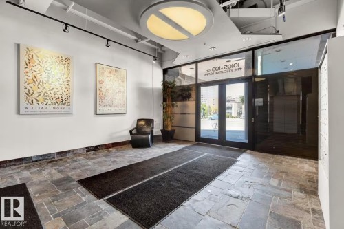 Slate tile flooring, double glass entry doors, track lighting, ceiling-mounted light fixture, and floor-to-ceiling glass paneling - #904 10105 109 St Nw, Edmonton, AB 