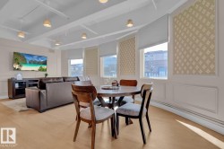 Recessed ceiling with visible ductwork, light wood-finish flooring, multiple windows with cellular shades, and decorative wall panels - 