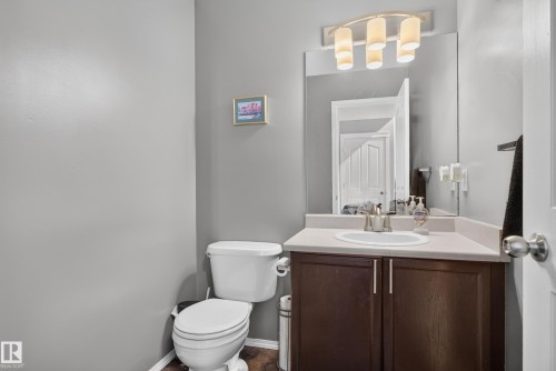 Vanity with an integrated sink, dark wood-finish cabinetry, and a neutral countertop - 9826 180 Avenue Nw, Edmonton, AB 