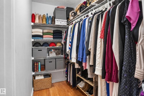 Closet featuring organized wire shelving, multiple hanging rods, wood-finish flooring, and light-toned walls - 9826 180 Avenue Nw, Edmonton, AB 