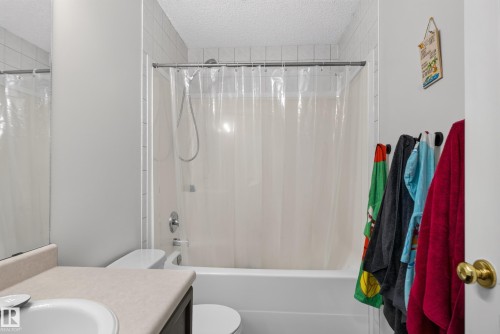 White bathtub with chrome fixtures and tiled surround - 9826 180 Avenue Nw, Edmonton, AB 