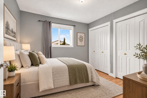 Wood-finish flooring, white panel bi-fold closet doors, and a window with natural light - 9826 180 Avenue Nw, Edmonton, AB 