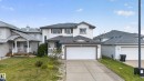 Two-story exterior with white siding, dark shutters, an attached two-car garage, an extended concrete driveway, and a covered entry - 9826 180 Avenue Nw, Edmonton, AB 