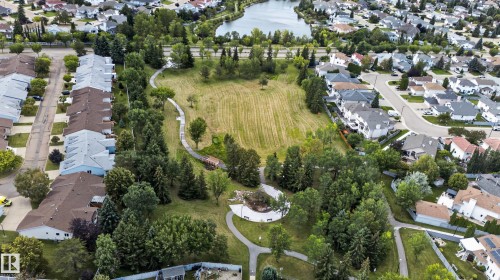 Aerial perspective showcasing a residential area with a prominent park, winding pathways, and a large body of water - 9826 180 Avenue Nw, Edmonton, AB 