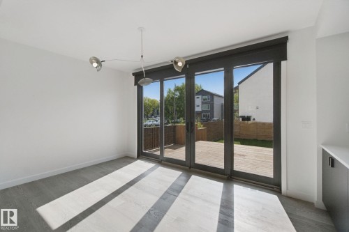 Expansive glass sliding doors open to an outdoor deck - 10925 University Avenue Nw, Edmonton, AB 