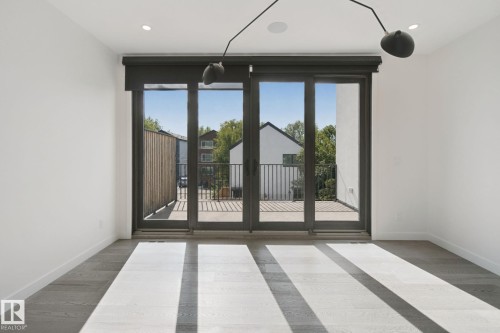 Wood-finish flooring, recessed lighting, and a modern ceiling fixture - 10925 University Avenue Nw, Edmonton, AB 