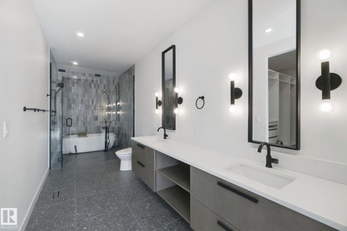 Dual vanity with white countertops, integrated sinks, and matte black fixtures - 10925 University Avenue Nw, Edmonton, AB 